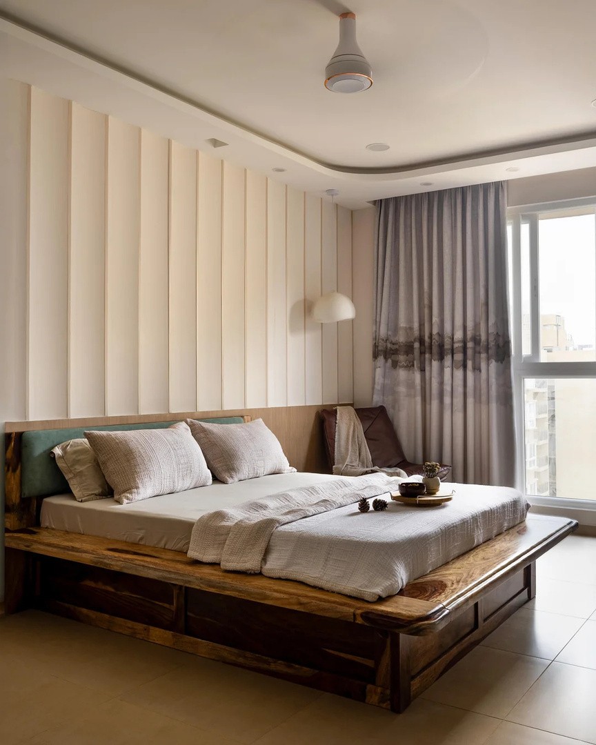 Bedroom with timber bed, panelled wall and curtains